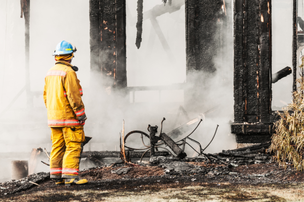 Man looking at burnt building